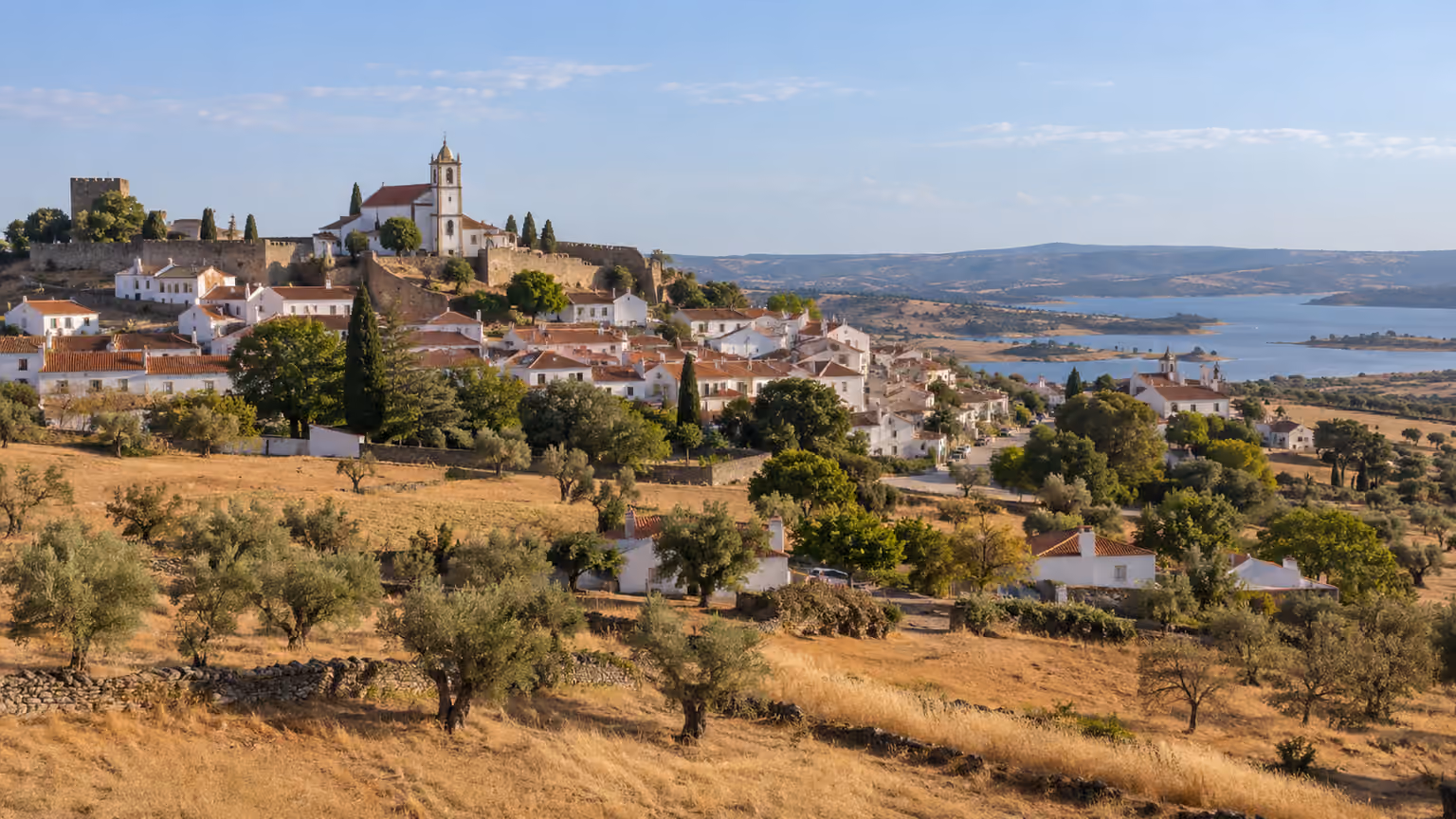 A small whitewashed Alentejo Portugal village with terracotta roofs and surrounding dry golden