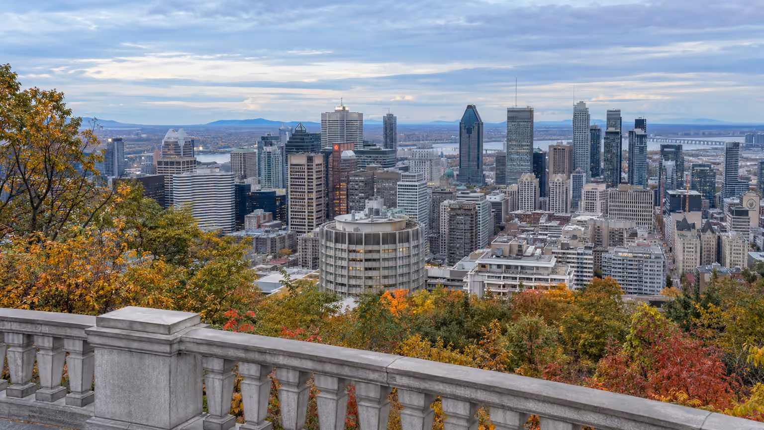 Montreal skyline seen from Mount Royal's Kondiaronk lookout with the low stone balustrade and
