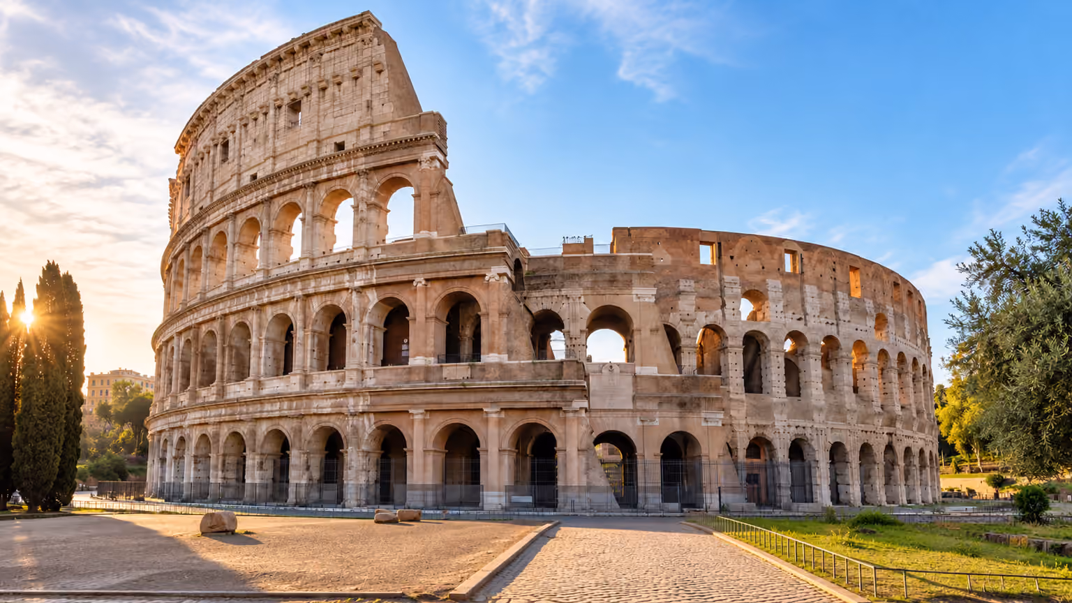 The Colosseum’s stone arches in warm morning light in Rome