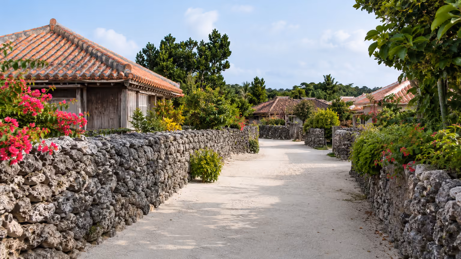 A traditional sandy village lane on Taketomi Island Japan with low Ryukyu-style red-tile roofs
