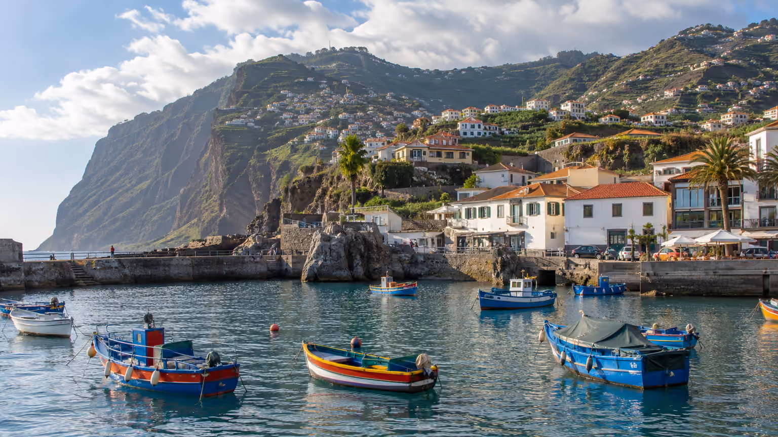 The fishing village waterfront at Camara de Lobos Madeira with small traditional boats and steep