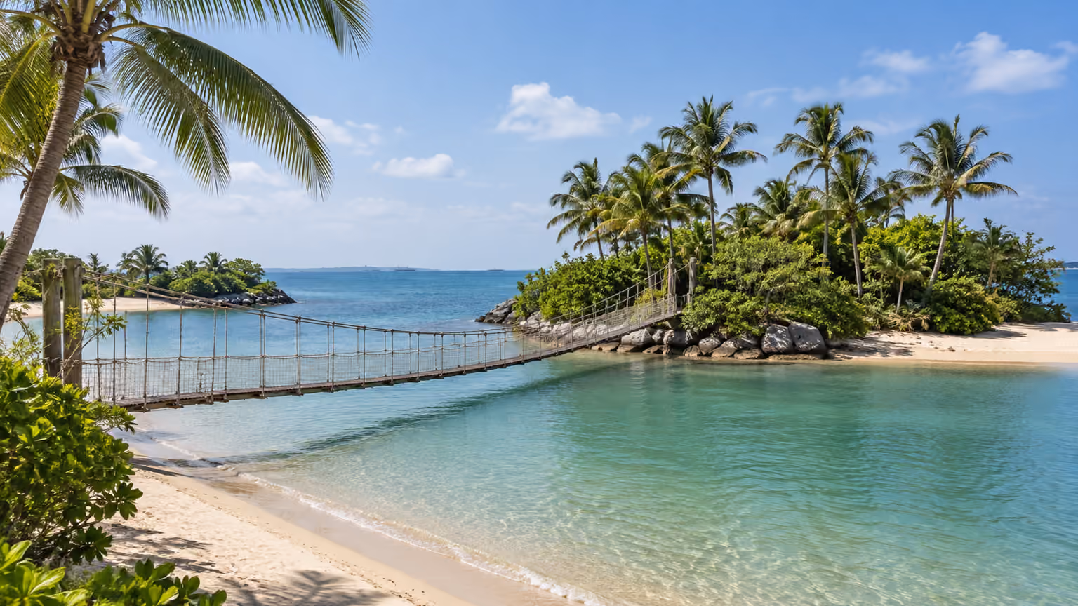 A low suspension bridge to a palm-covered islet beside Sentosa’s Palawan Beach
