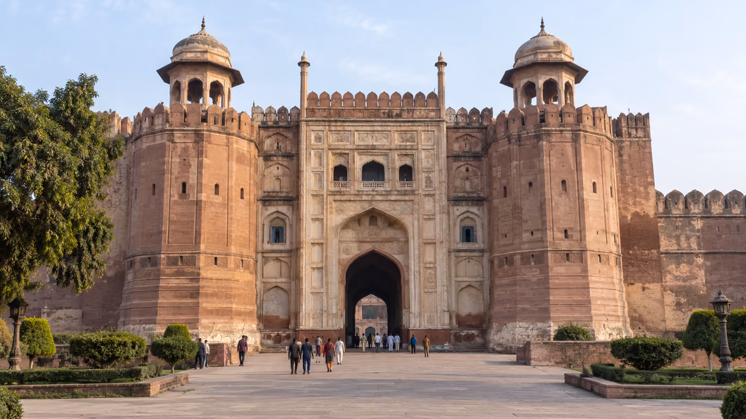 The monumental Alamgiri Gate of Lahore Fort in warm daylight with visitors for scale